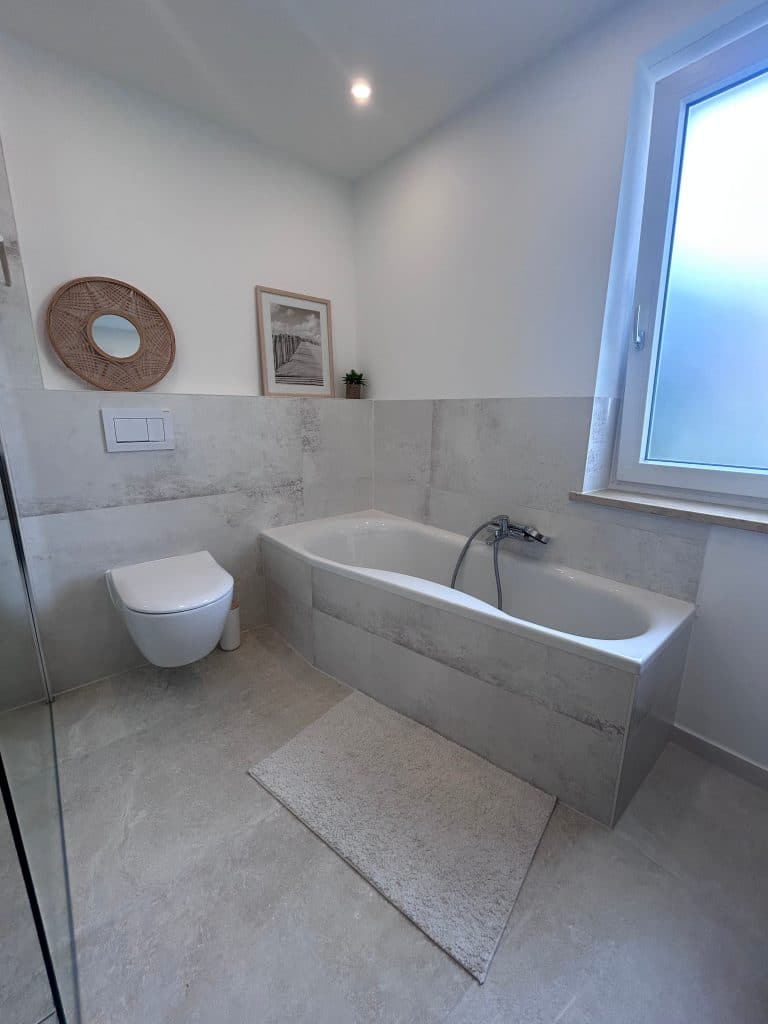 Modernes Badezimmer mit LED-Beleuchtung und Wanne nach Badsanierung in Augsburg